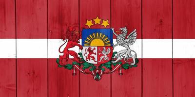 bandeira da letônia em um plano de fundo texturizado. colagem de conceito. foto