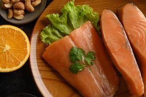 pedaços de salmão em um prato de madeira foto