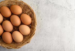 ovos marrons frescos em uma cesta de vime foto
