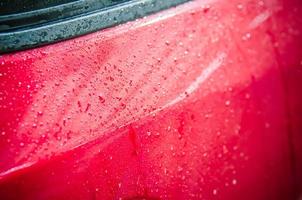 gotas d'água em um carro vermelho foto