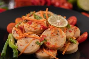 Salada de linguiça de porco vietnamita com pimenta, limão, alho e tomate foto