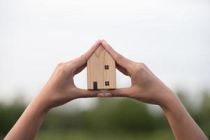 novo conceito de casa - família jovem com modelo em escala de casa dos sonhos nas mãos foto