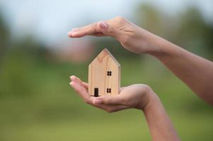 novo conceito de casa - família jovem com modelo em escala de casa dos sonhos nas mãos foto