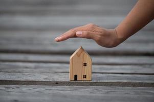 novo conceito de casa - família jovem com modelo em escala de casa dos sonhos nas mãos foto