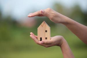 novo conceito de casa - família jovem com modelo em escala de casa dos sonhos nas mãos foto