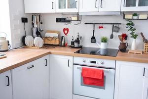 o interior da cozinha da casa é decorado com corações vermelhos para o dia dos namorados. decoração na mesa, fogão, utensílios, clima festivo em ninho familiar foto