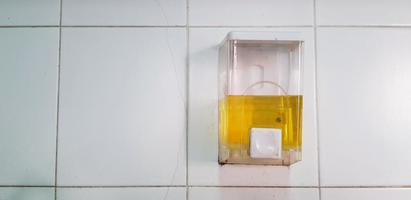 detergente líquido em caixa branca para limpeza de utensílios de cozinha, prato ou prato instalado no fundo da parede do título branco com espaço de cópia. líquido amarelo e objeto para lavar colher ou garfo e louça foto