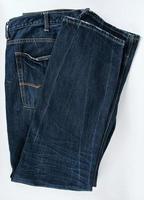 calça jeans masculina azul dobrada em um fundo branco foto