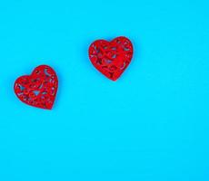 dois corações decorativos vermelhos em um fundo azul foto