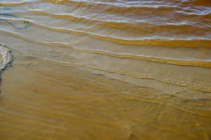 margem do lago de cura iodado com água marrom no meio da estepe foto