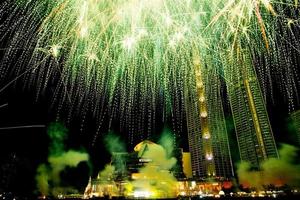 comemoração de ano novo, multidão e fogos de artifício coloridos perto do rio, tailândia foto