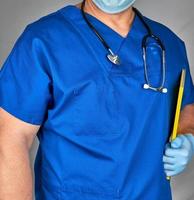 médico de uniforme azul e luvas de látex estéreis foto