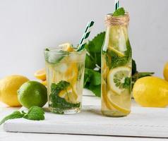 bebida refrescante de verão limonada com limões, folhas de hortelã, limão em um copo foto