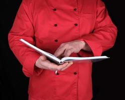 chef de uniforme vermelho segurando o bloco de notas aberto foto