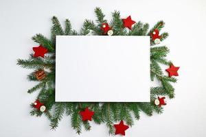 fundo de natal de felicitações com um lençol branco vazio e ramos verdes de abeto foto