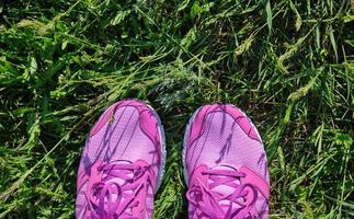 tênis feminino rosa com cadarços na grama verde fresca, foto