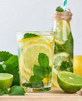 bebida refrescante de verão limonada com limões, folhas de hortelã, limão em um copo foto