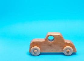 carro infantil de madeira sobre um fundo azul foto