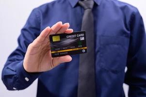 homem segurando um cartão de crédito preto foto