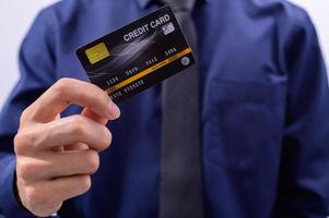 profissional segurando um cartão de crédito preto foto