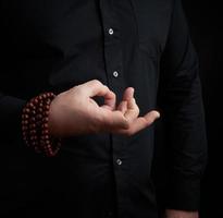 mão masculina mostra mudra em um fundo escuro foto