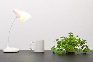 lâmpada e caneca de café com uma planta foto