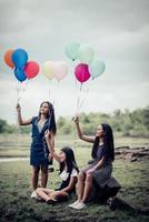 namoradas felizes segurando balões multicoloridos em um parque foto