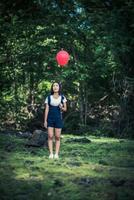 jovem segurando balões coloridos na natureza foto