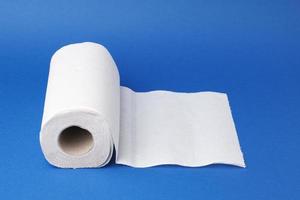 rolo torcido de toalha de papel branco sobre um fundo azul foto