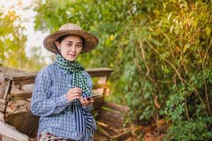 agricultora usando tecnologia móvel no campo de arroz foto