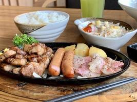 vários menus, sushi, sashimi, nigiri, carne de porco frita e sopa de missô. sashimi, sashimi chutoro, pauzinhos de comida japonesa e wasabi na mesa preta, estilo de comida japonesa. desfoca o foco. foto