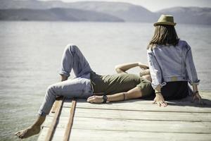 jovens amigos relaxando à beira de um lago. foto