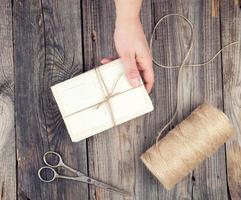 mão feminina segurando uma pilha de cartas amarradas com uma corda marrom foto