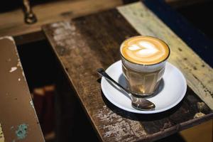 café com leite em mesa rústica escura foto