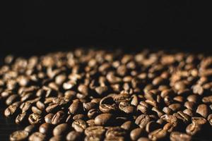 close-up de grãos de café em fundo preto foto