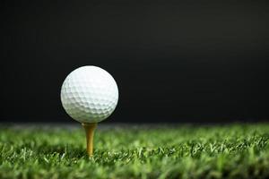 bola de golfe no tee à noite foto