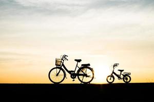 duas bicicletas de silhueta vintage ao pôr do sol foto