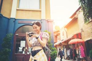 mulher jovem hippie tirando fotos em uma área urbana