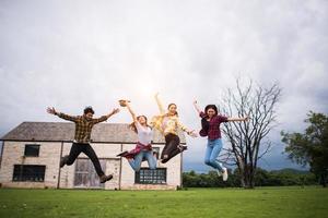 grupo feliz de estudantes adolescentes pulando juntos em um parque