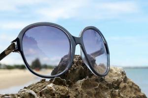 óculos de sol na rocha foto