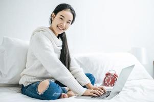 uma jovem feliz brincando em seu laptop foto