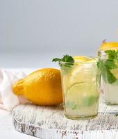 bebida refrescante de verão limonada com limões, folhas de hortelã foto