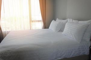 cama branca feita em hotel foto