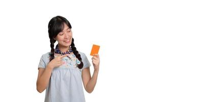 retrato de uma bela jovem asiática feliz em vestido jeans segurando cartão de crédito em fundo branco foto