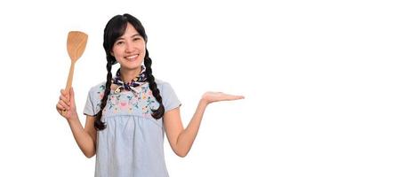 retrato da bela jovem mulher asiática sorrir em vestido jeans com espátula em fundo branco foto