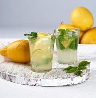 bebida refrescante limonada com limões, folhas de hortelã, limão em um copo foto
