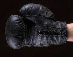 mão na luva de boxe de couro preto foto