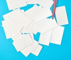 pilha de cartões de visita brancos de papel retangular em branco sobre um fundo azul foto