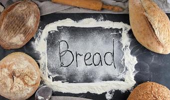 pão de inscrição na farinha de trigo branca espalhada foto