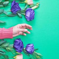 mão feminina em um suéter rosa brilhante sobre um fundo verde foto